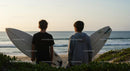 Young Surfers at Ocean Sunset with Surfboards