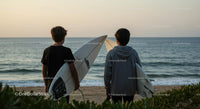 Young Surfers at Sunset on a Serene Beach