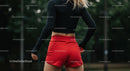 Athletic Woman in Red Shorts Preparing for Workout