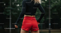 Athletic Woman in Red Shorts Preparing for Workout