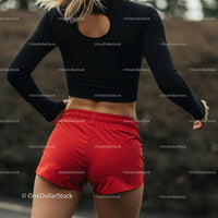 Athletic Woman Running Outdoors in Red Shorts