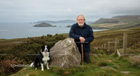 Elderly Man with Border Collie in Scenic Coastal Landscape