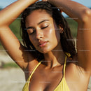 Woman Enjoying Sunlight on a Beach in a Yellow Swimsuit
