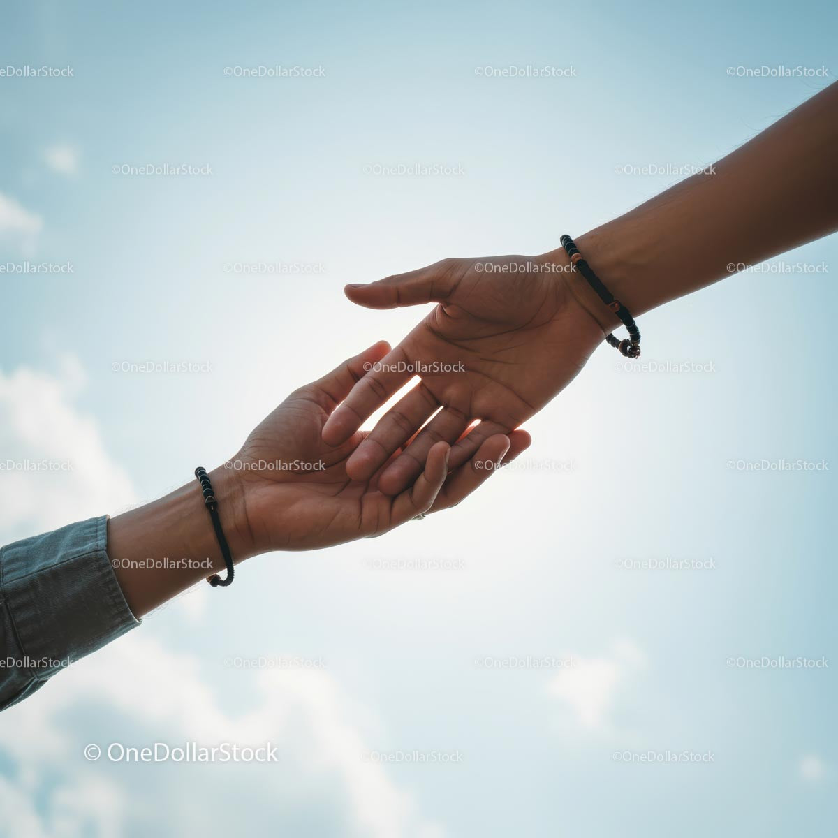 Hands Reaching Out Against a Blue Sky Background