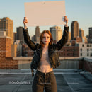 Confident Woman Holding Sign on Urban Rooftop at Sunset