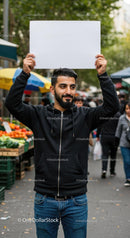 Man Holding Blank Sign in Vibrant Street Market
