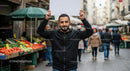 Man Holding Blank Sign in Bustling Market Street