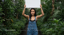 Woman Holding Blank Sign Among Lush Greenery