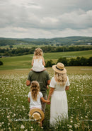 Family Walking in Summer Meadow with Rolling Hills