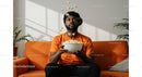 Man Enjoying Popcorn on Bright Orange Couch