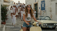 Young Woman on Vintage Scooter with Friends in Sunny Town