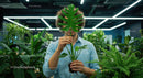 Man Holding Monstera Leaf in Modern Office Setting