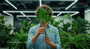 Person Holding Monstera Leaf in Modern Office