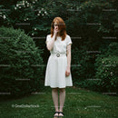 Redhead Woman in White Dress in Lush Green Garden