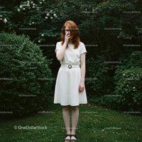 Redhead Woman in White Dress in Lush Green Garden