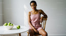 Woman in Pink Romper with Green Apples on White Table