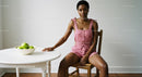 Woman in Pink Jumpsuit Sitting by White Table with Apples