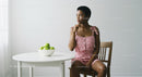Thoughtful Woman in Pink Dress with Green Apples
