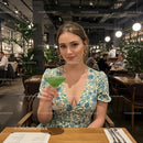 Woman Enjoying Green Cocktail in Chic Restaurant Setting