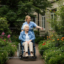 Caregiver and Senior Woman in a Lush Garden Walk
