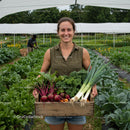 Smiling Farmer Holding Freshly Harvested Vegetables on Farm
