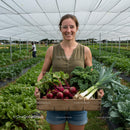 Smiling Farmer with Fresh Harvest in Greenhouse