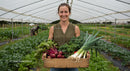 Woman Holding Organic Vegetables in Greenhouse