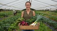 Woman Holding Organic Vegetables in Greenhouse