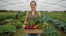 Woman Farmer Holding Fresh Harvest in a Greenhouse