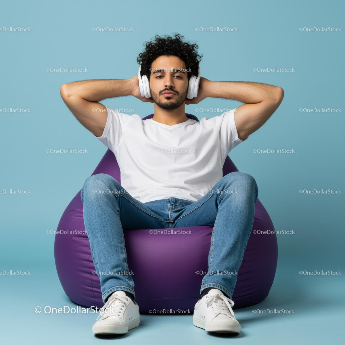 Young Man Relaxing with Headphones on Purple Bean Bag