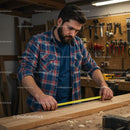 Focused Carpenter Measuring Wood in Workshop