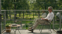 Man Enjoying Remote Work on Balcony with Park View