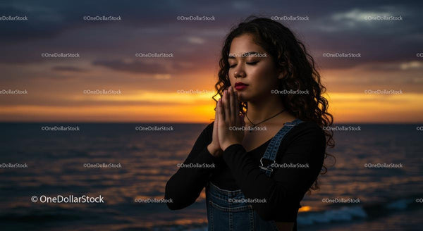 Woman Meditating Peacefully at Sunset by the Ocean