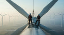Technicians Maintaining Wind Turbine at Sunrise