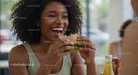 Joyful Woman Enjoying a Fresh Sandwich in a Bright Cafe