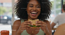 Joyful Woman Enjoying a Fresh Sandwich Indoors