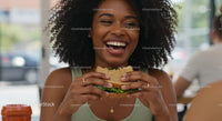 Joyful Woman Enjoying a Fresh Sandwich Indoors