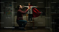 Father and Daughter Play in Superhero Costume at Home
