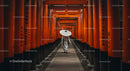 Man Walking Through Vibrant Orange Torii Gates in Kyoto