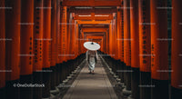 Man Walking Through Vibrant Orange Torii Gates in Kyoto