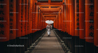 Man Walking Through Vibrant Orange Torii Gates in Kyoto