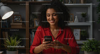 Woman Joyfully Using Phone in Cozy Home Office