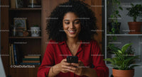 Happy Woman Using Smartphone in Cozy Home Office Setting