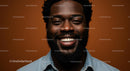 Smiling Portrait of a Man in Denim Against Brown Background