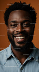 Smiling Man in Denim Shirt Against Orange Background