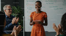 Confident Woman Giving Engaging Presentation in Orange Dress