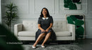 Smiling Woman in Polka Dot Dress on a White Sofa in Modern Living Room