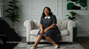Smiling Woman in Polka Dot Dress on White Sofa