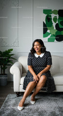Smiling Woman in Polka Dot Dress on White Sofa