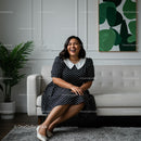 Smiling Woman in Polka Dot Dress in Cozy Living Room